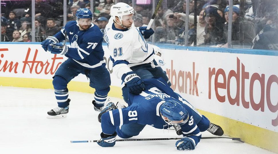 Tampa Bay Lightning's Steven Stamkos (91) goes to the boards with Toronto Maple Leafs' John Tavares during the third period of an NHL hockey game, Tuesday, Dec. 20, 2022 in Toronto. (Chris Young/The Canadian Press via AP)