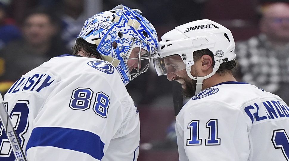 Tampa Bay Lightning goalie Andrei Vasilevskiy (88) and Luke Glendening (11) celebrate after they defeated the Vancouver Canucks in NHL hockey game action in Vancouver, British Columbia, Sunday, Dec. 8, 2024. (Darryl Dyck/The Canadian Press via AP)