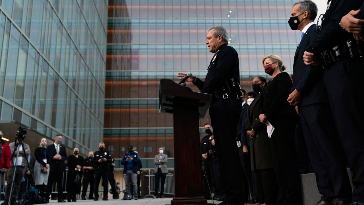 Los Angeles Police Chief Michel Moore, center, speaks during a news conference as he is joined by Mayor Eric Garcetti, second from right, outside the Los Angeles Police Headquarters, Dec. 2, 2021. (AP Photo/Jae C. Hong)