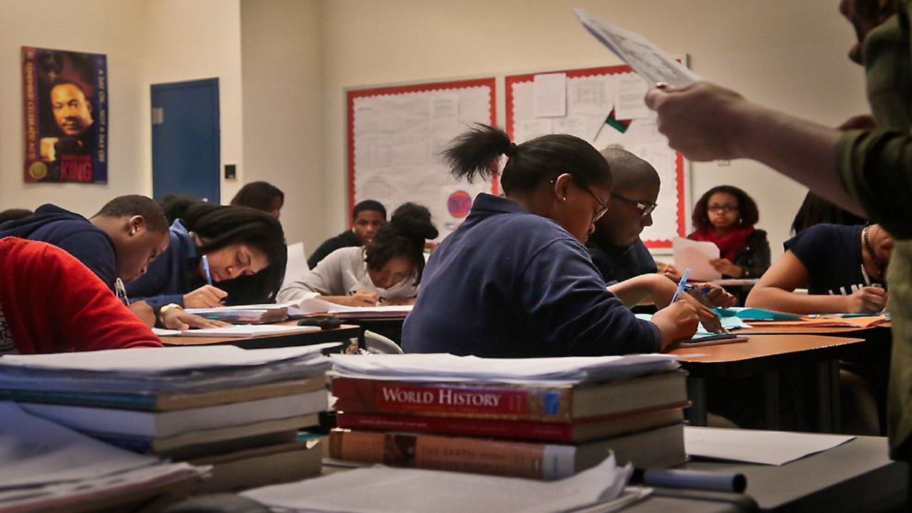 A classroom of students work on schoolwork