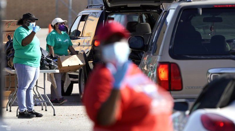 In this May 11, 2020 file photo, Houston Independent School District nutrition services employees distribute food at Kashmere High School amid the COVID-19 pandemic in Houston. (AP Photo/David J. Phillip File)