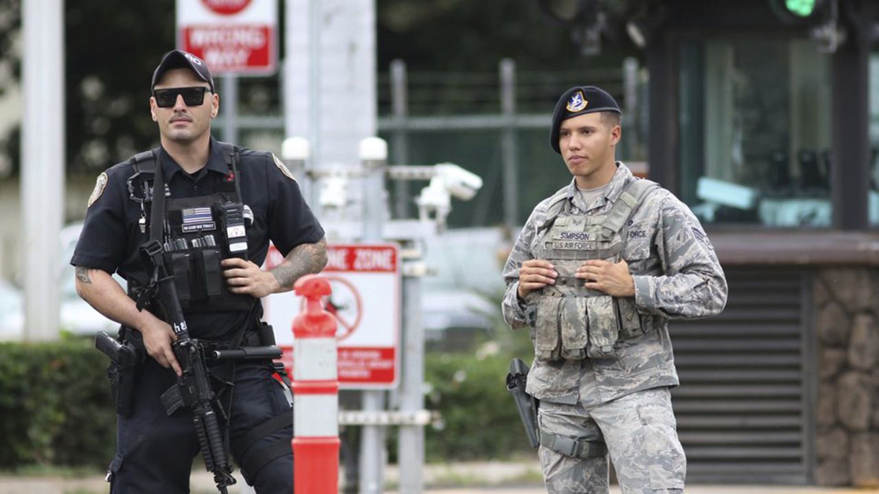 Security stands guard outside the main gate at Joint Base Pearl Harbor-Hickam, in Hawaii, Wednesday, Dec. 4, 2019, in response to a shooting at the Pearl Harbor Navy Shipyard. (AP Photo/Caleb Jones)