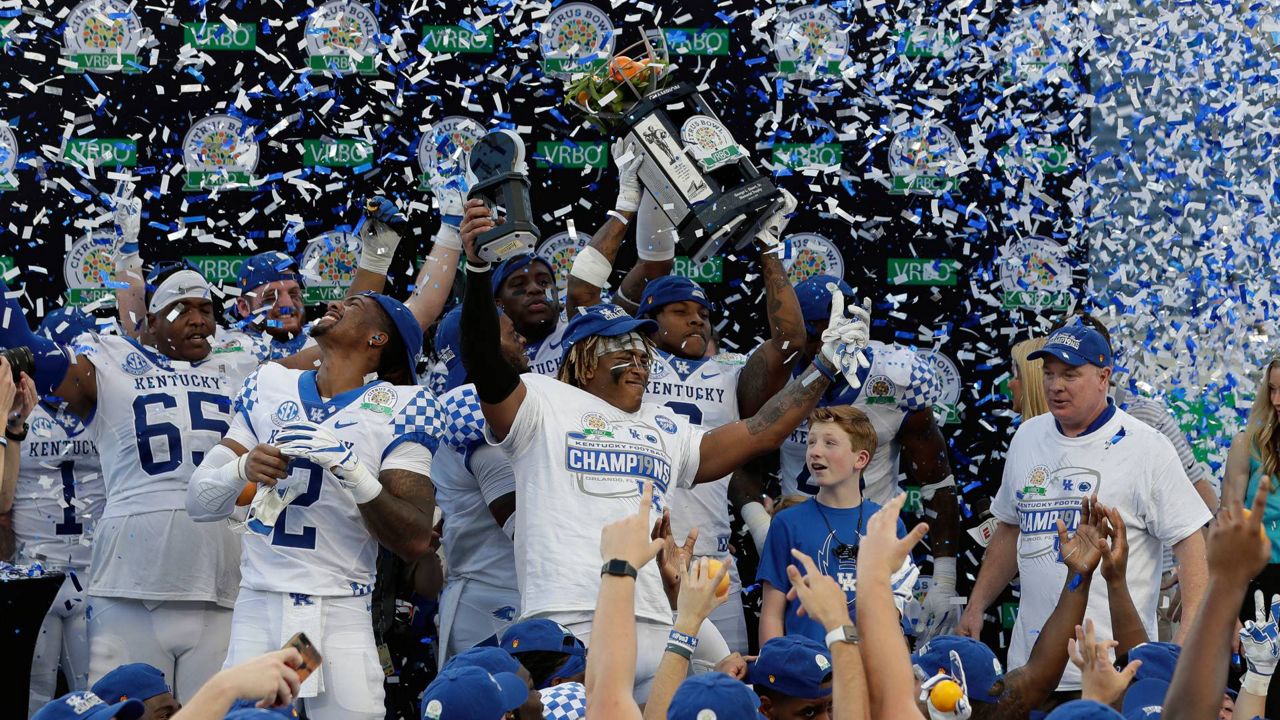 Kentucky players and coach Mark Stoops, right, celebrate after receive the championship trophy following a 27-24 win over Penn State in the Citrus Bowl NCAA college football game Tuesday, Jan. 1, 2019, in Orlando, Fla. (AP Photo/John Raoux)