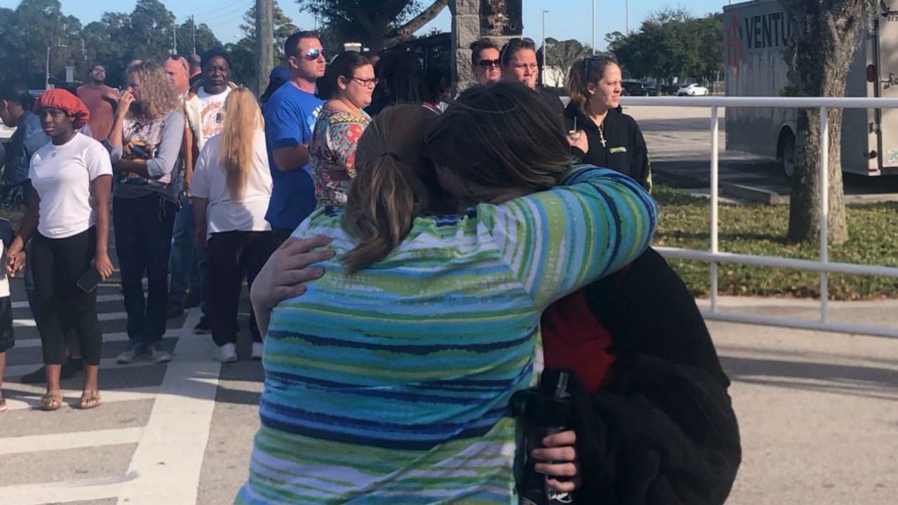 A parent hugs a student after a large fight at Atlantic High School leads to the arrest of 11 students and one adult. (Nicole Griffin, Spectrum News)