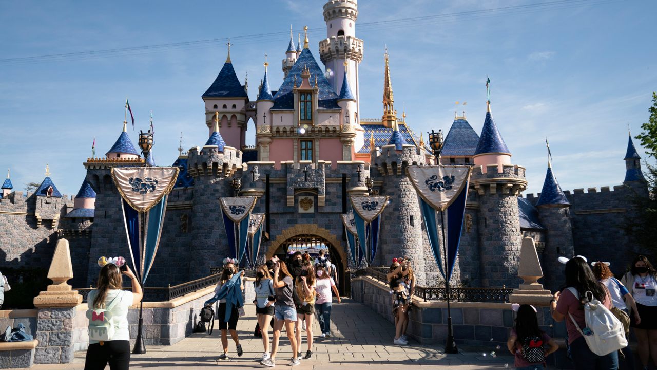 In this Friday, April 30, 2021, file photo, visitors exit The Sleeping Beauty Castle at Disneyland in Anaheim, Calif. (AP Photo/Jae C. Hong, File)