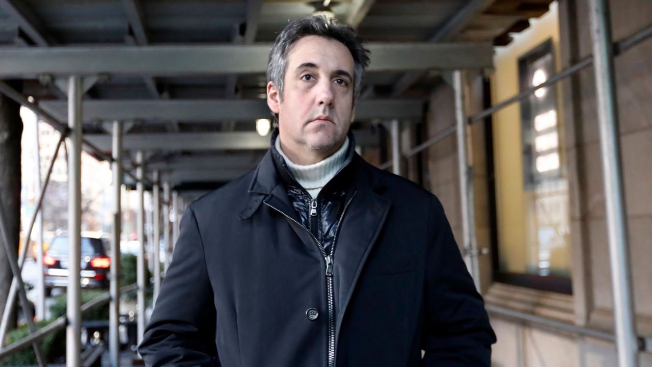 Michael Cohen wearing a black jacket and a white sweater.