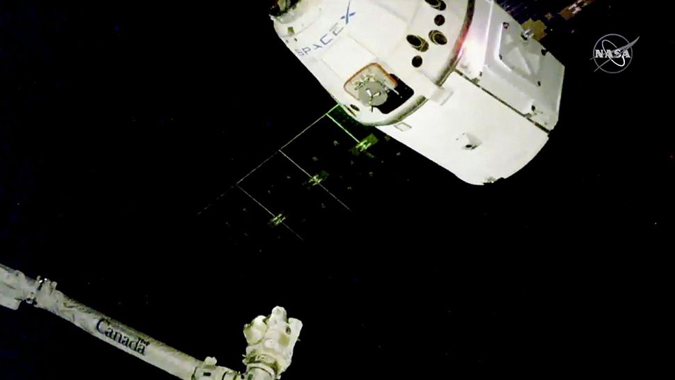 Image taken from NASA Television shows SpaceX Dragon capsule approaching the robotic arm for docking to the International Space Station. (Courtesy of NASA TV)
