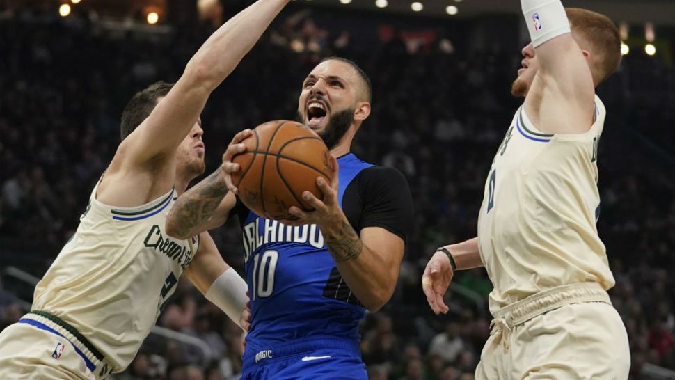 Orlando Magic's Evan Fournier drives between Milwaukee Bucks' Pat Connaughton and Donte DiVincenzo during the first half of an NBA basketball game Monday, Dec. 9, 2019, in Milwaukee. (AP Photo/Morry Gash)