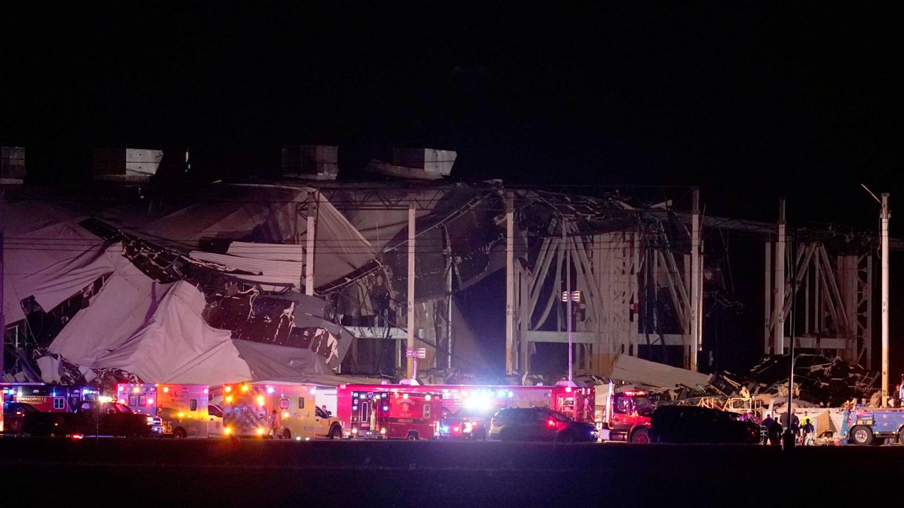 Emergency vehicles stage outside an Amazon fulfillment center after it was heavily damaged when a strong thunderstorm moved through the area Friday, Dec. 10, 2021, in Edwardsville, Ill. (AP Photo/Jeff Roberson)