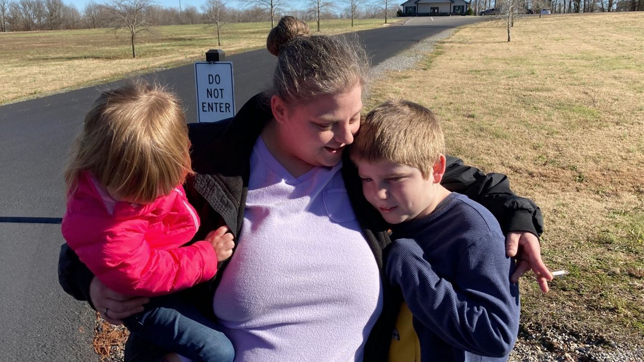 Autumn Kirks comforts her children, Sunday, Dec. 12, 2021, in Mayfield, Ky. Her boyfriend, Lannis Ward, has been missing since a tornado leveled the candle factory where they worked. (AP Photo/Bruce Schreiner)