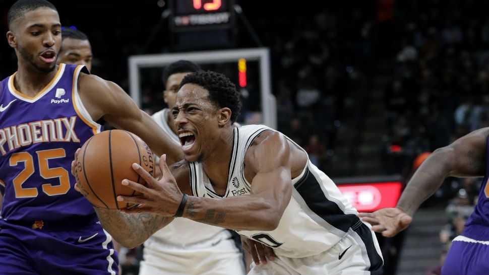 San Antonio Spurs guard DeMar DeRozan (10) reacts as he is fouled while driving to the basket past Phoenix Suns forward Mikal Bridges (25) during the second half of an NBA basketball game, Tuesday, Dec. 11, 2018, in San Antonio. (AP Photo/Eric Gay)