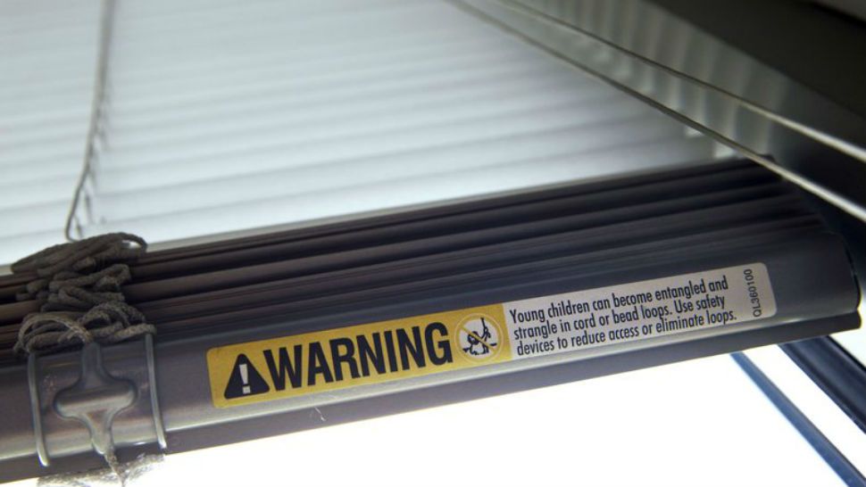 FILE - This Wednesday, May 6, 2015 file photo shows a warning label of strangulation risks from mini blind cords in Washington. According to a study released on Monday, Dec. 11, 2017, children’s injuries and deaths from window blinds have not stalled despite decades of safety concerns. (AP Photo/Jacquelyn Martin)