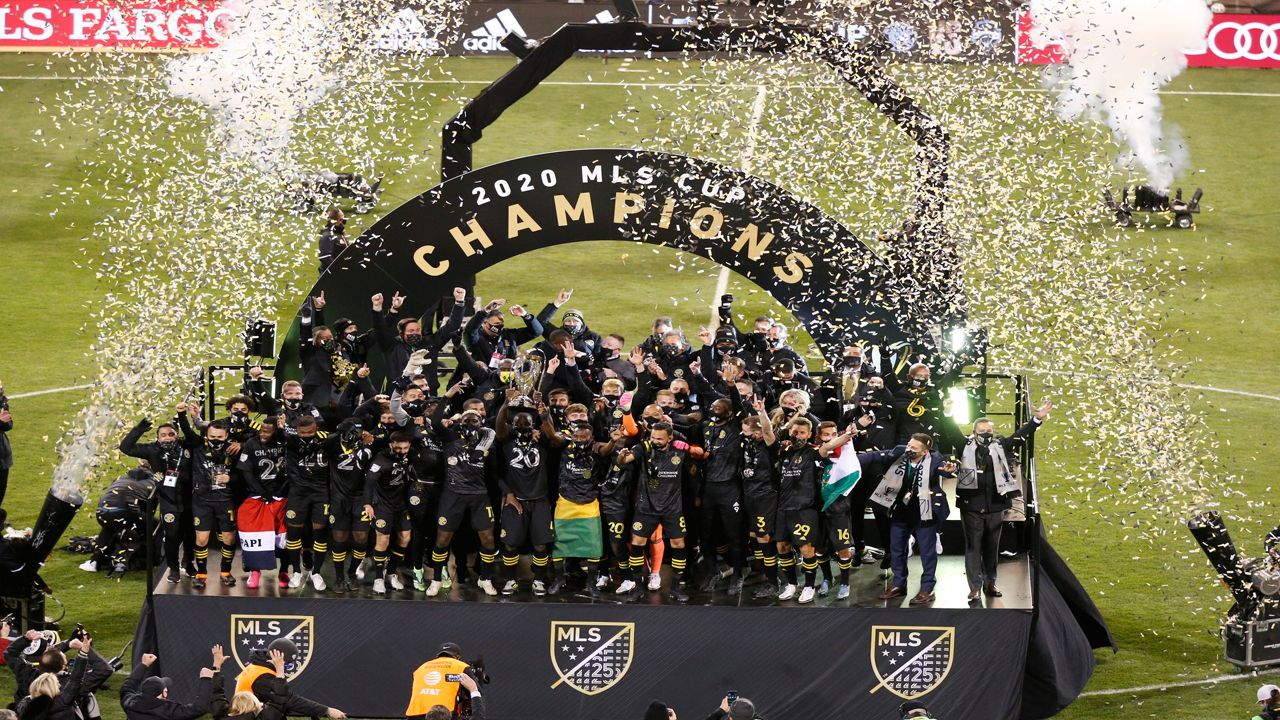 A soccer team celebrates a championship on a stage