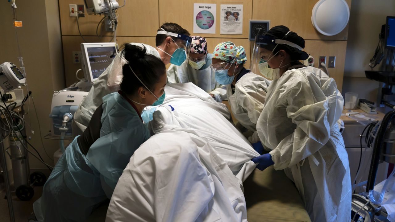  Medical personnel prone a COVID-19 patient at Providence Holy Cross Medical Center in the Mission Hills section of Los Angeles on Nov. 19, 2020. (AP Photo/Jae C. Hong)