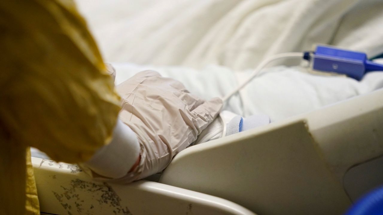 A hospital worker near a bed