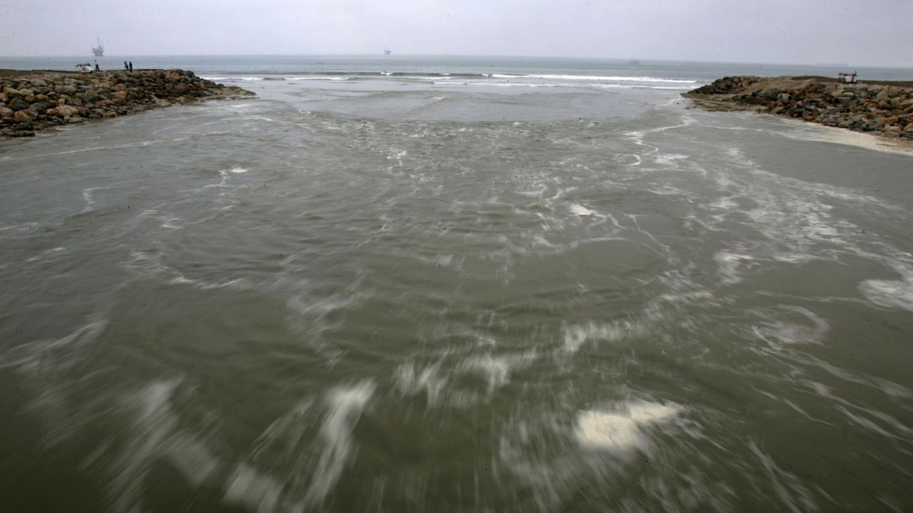 Water from the pacific ocean washes away the last barrier of sand from a large berm, allowing seawater to flood the Bolsa Chica wetlands. (AP Photo/Chris Carlson)