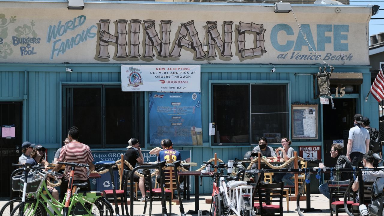 Restaurant patrons sit at an outside seating area in the Venice beach area of Los Angeles on Friday, July 3, 2020. (AP Photo/Richard Vogel)