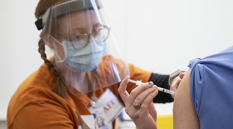 Nursing student Kristen Tucker administers the Pfizer-BioNTech COVID-19 vaccine to Dr. Mitchell Katona at the University of Texas Health Austin Dell Medical School on Tuesday, Dec. 15, 2020, in Austin, Texas. (Jay Janner/Austin American-Statesman via AP)