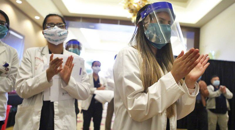 Attendees applaud as DHR Health administers their first batch of the COVID-19 vaccines at the Edinburg Conference Center at Renaissance on Wednesday, Dec. 16, 2020, in Edinburg, Texas. (Joel Martinez/The Monitor via AP)