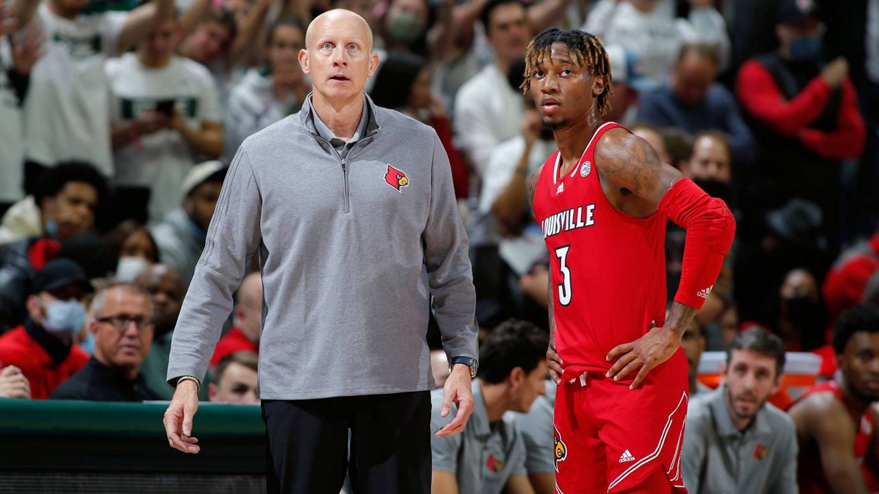 Louisville coach Chris Mack, left, talks with El Ellis during the second half of an NCAA college basketball game against Michigan State, Wednesday, Dec. 1, 2021, in East Lansing, Mich. Michigan State won 73-64. (AP Photo/Al Goldis)