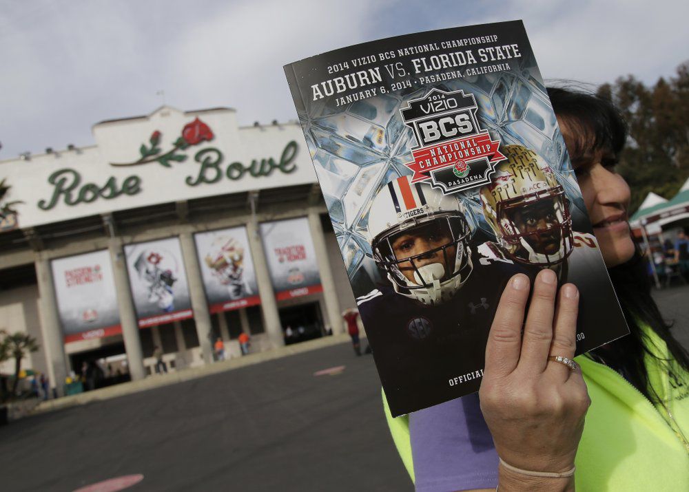 In this Jan. 6, 2014, file photo, a vendor sells a program outside the Rose Bowl before the BCS National Championship NCAA college football game between Auburn and Florida State in Pasadena, Calif. (AP Photo/Chris Carlson, File)