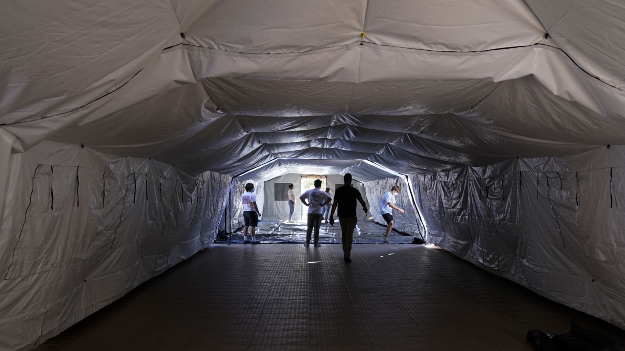 Volunteers help set up a mobile field hospital at UCI Medical Center, Monday, Dec. 21, 2020, in Orange, Calif. (AP Photo/Jae C. Hong)