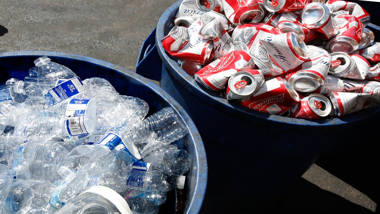 A trash can of plastic bottles and aluminum cans