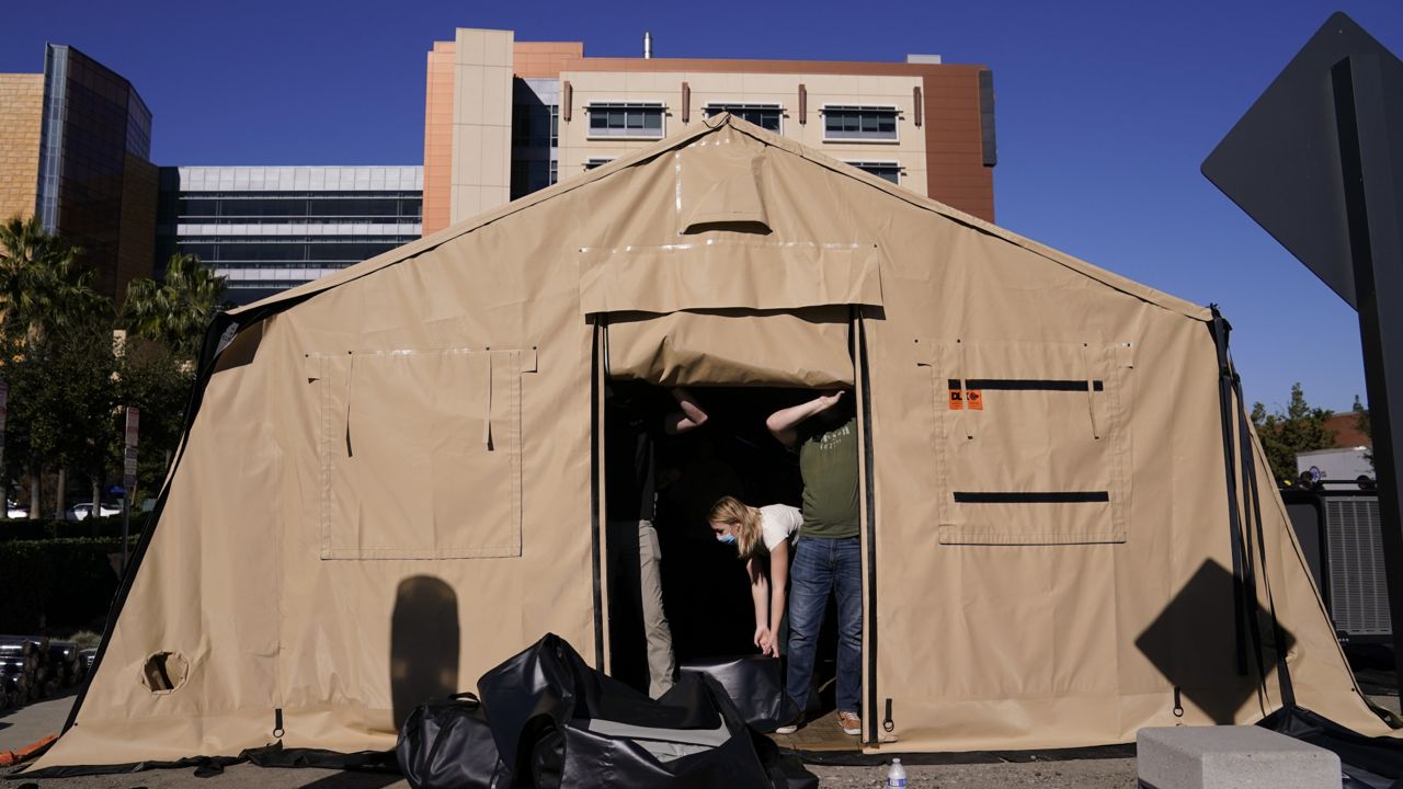 Volunteers help set up a mobile field hospital at UCI Medical Center, Monday, Dec. 21, 2020, in Orange, Calif. (AP Photo/Jae C. Hong)