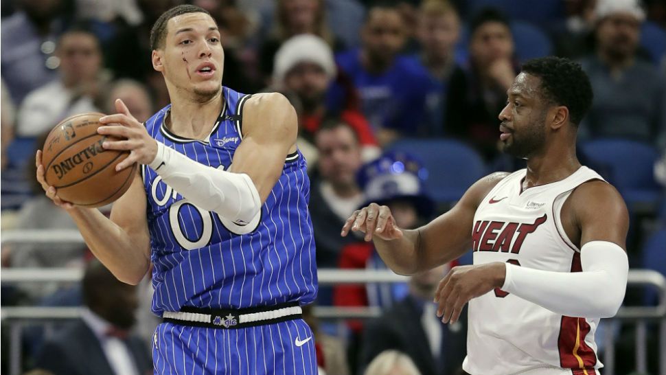 Orlando Magic's Aaron Gordon, left, looks to pass as he is defended by Miami Heat's Dwyane Wade during the first half of an NBA basketball game, Sunday, Dec. 23, 2018, in Orlando, Fla. (AP Photo/John Raoux)