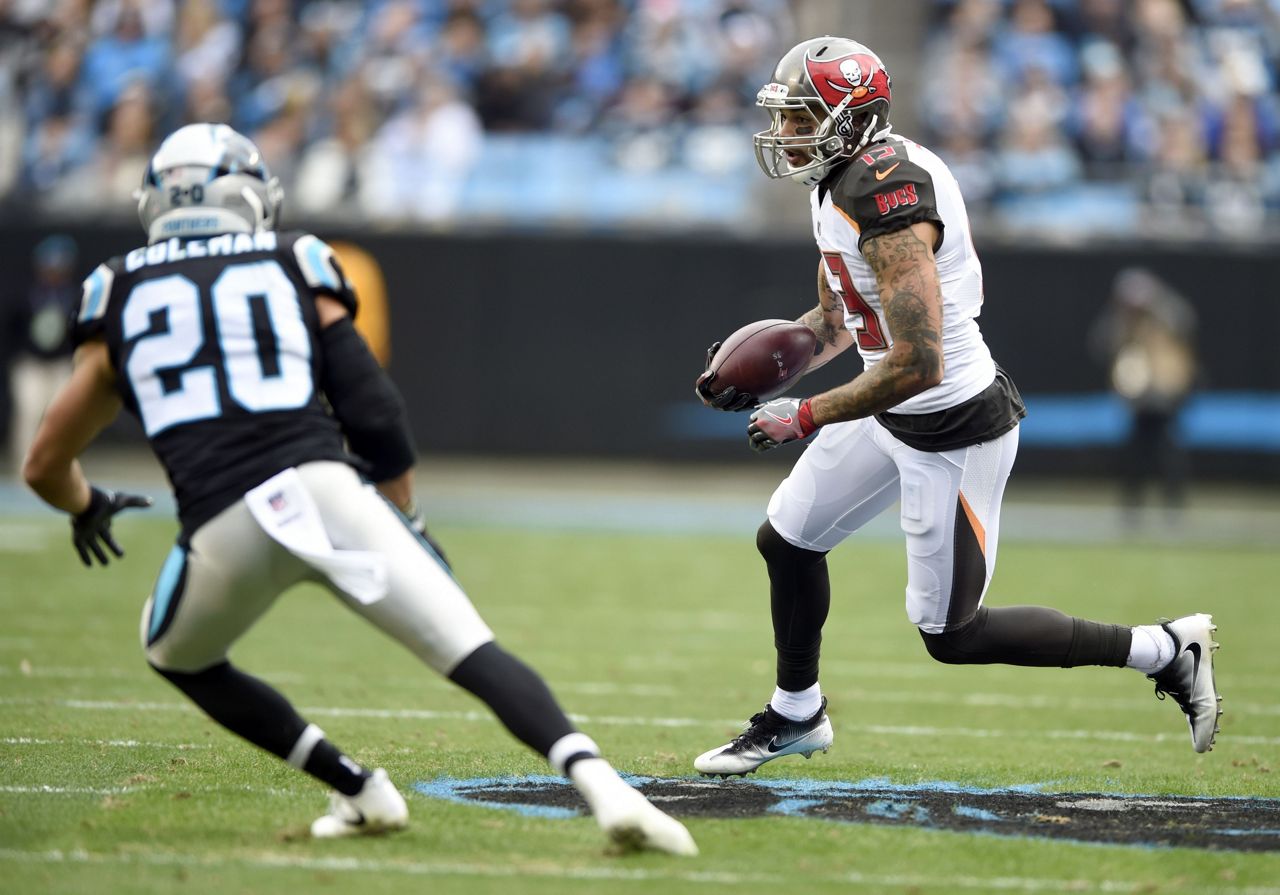 Tampa Bay Buccaneers' Mike Evans (13) runs after a catch as Carolina Panthers' Kurt Coleman (20) defends during the first half of an NFL football game in Charlotte, N.C., Sunday, Dec. 24, 2017. (AP Photo/Mike McCarn)