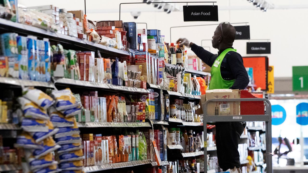 An associate arranges items on a store shelf. (AP Photo/Mark Lennihan)