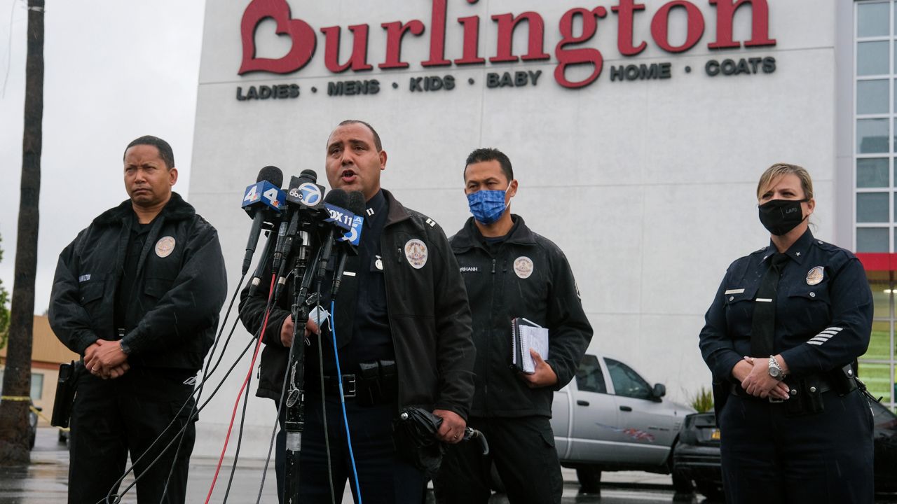 Los Angeles Police Department PIO Capt. Stacy Spell, second from left, speaks in a press conference at the scene where two people were struck by gunfire in a shooting at a Burlington store — part of a chain formerly known as Burlington Coat Factory in North Hollywood, Calif., Thursday, Dec. 23, 2021. (AP Photo/Ringo H.W. Chiu)