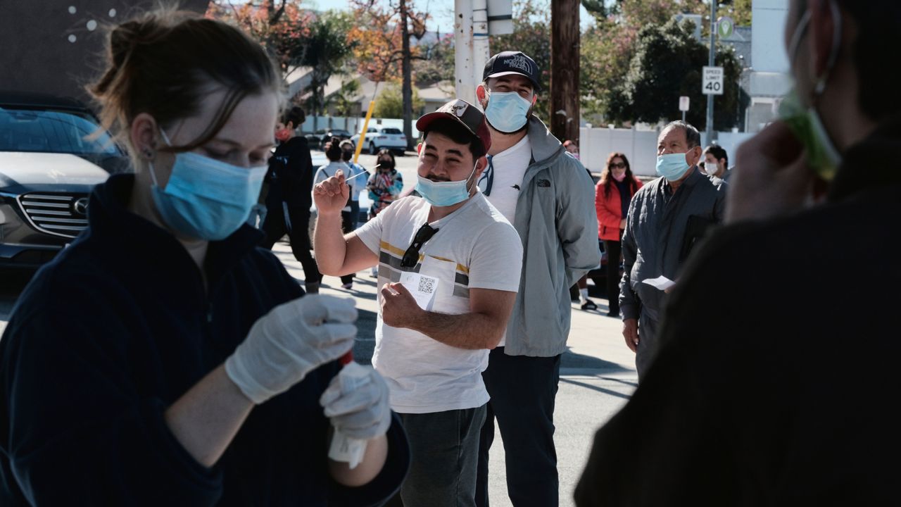 People line up at a gas station for a free COVID-19 rapid test as California braces for a post-holiday virus surge in the Reseda section of Los Angeles on Sunday, Dec. 26, 2021. (AP Photo/Richard Vogel)