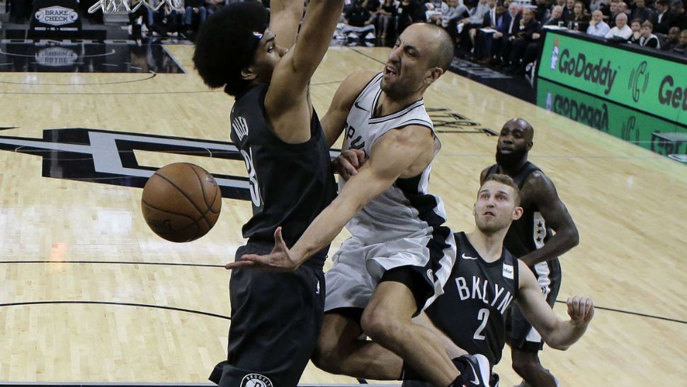 San Antonio Spurs Manu Ginobili, center, drives to the basket past Brooklyn Nets center Jarrett Allen, left, during the first half of an NBA basketball game, Tuesday, Dec. 26, 2017. (AP/Eric Gay)