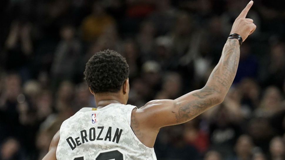 An image of San Antonio Spurs guard DeMar DeRozan from behind with his hand extended during play of an NBA game (AP Image/File)