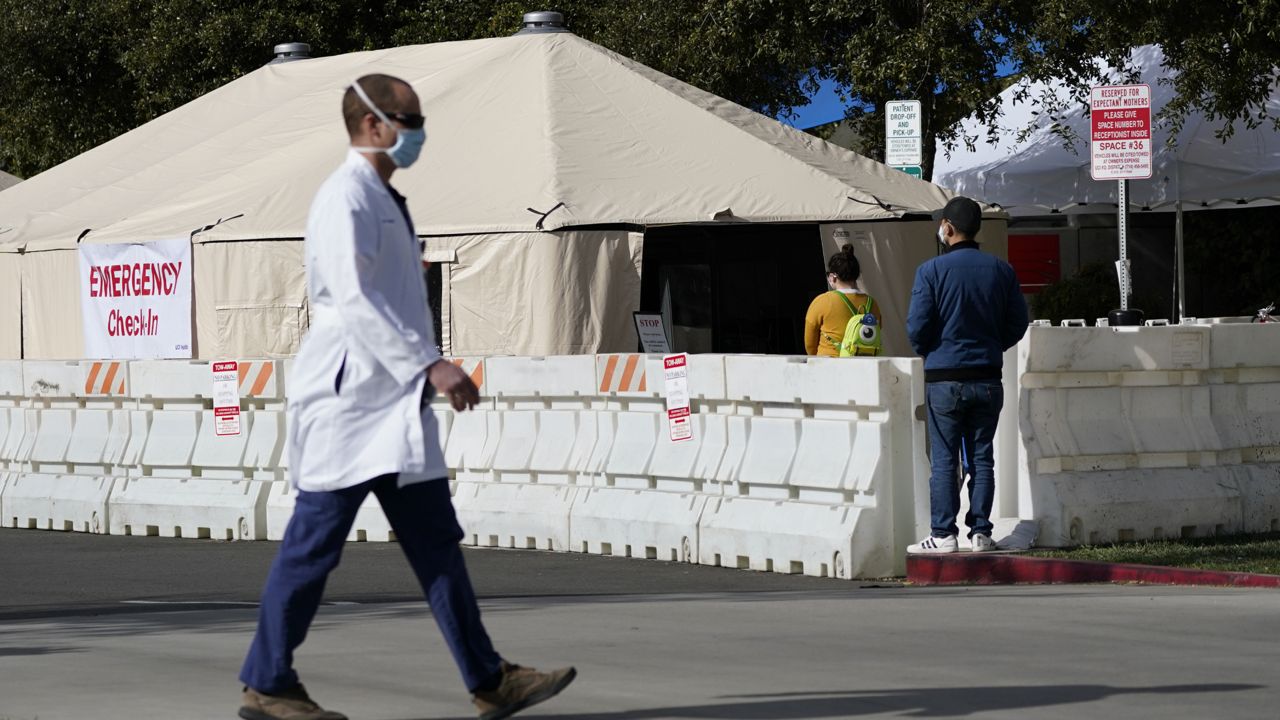 A medical worker passes a medical tent outside the emergency room at UCI Medical Center in Irvine, Calif. on Dec. 17, 2020. (AP Photo/Ashley Landis, File)