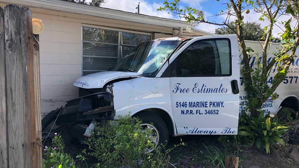 Image showing van still in place where it impacted against the house in Holiday, Tuesday, December 11, 2018. (Tim Wronka/Spectrum Bay News 9)