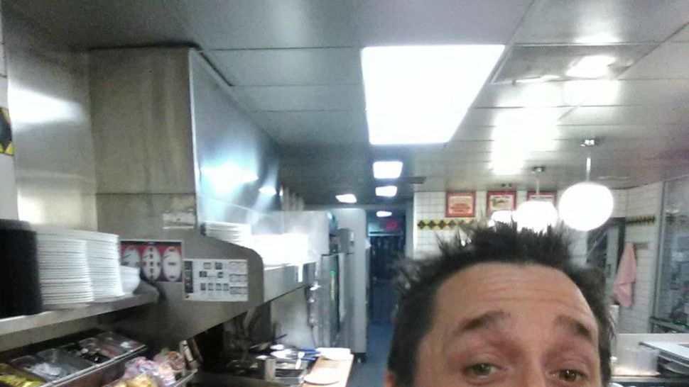 In this image taken early Thursday, Nov. 30, 2017, Alex Bowen poses in the kitchen at a Waffle House in West Columbia, S.C. When Bowen found the only worker at the empty South Carolina Waffle House asleep, he took his meal into his own hands. Bowen chronicled with selfies how he made his own double Texas bacon cheese steak melt on Facebook (The Associated Press)