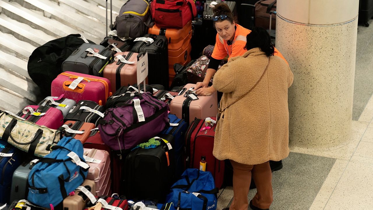 A Southwest Airlines employee helps a traveler search for bags amongst hundreds of other checked bags at baggage claim at Midway International Airport as Southwest continues to cancel thousands of flights across the country Wednesday, Dec. 28, 2022, in Chicago. (AP Photo/Erin Hooley)