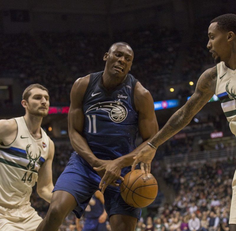 Orlando Magic center Bismack Biyombo, center, is defended by the Milwaukee Bucks during the first half of an NBA basketball game Monday, April 9, 2018, in Milwaukee. (AP Photo/Darren Hauck)