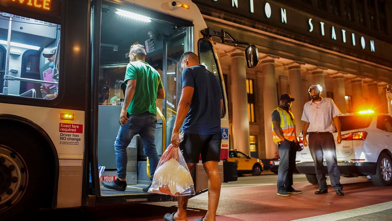 A group of people board a Chicago Transit Authority bus before being taken to a Salvation Army after arriving on a bus with other migrants from Texas at Union Station, Wednesday, Aug. 31, 2022, in Chicago. (Armando L. Sanchez/Chicago Tribune via AP)