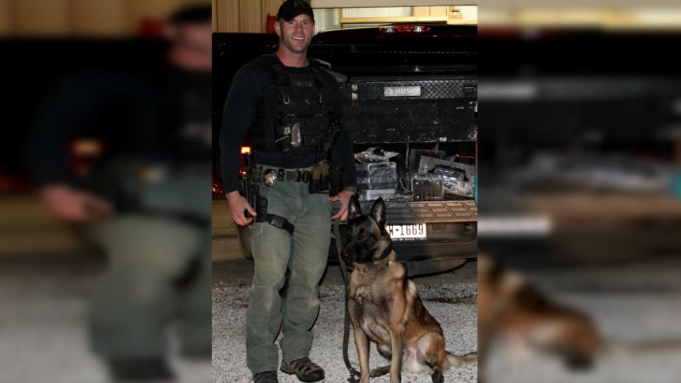 Sgt. Randy Thumann his canine partner Kolt stand in front of a pile of meth (Photo Credit: Fayette County Sheriff’s Office)