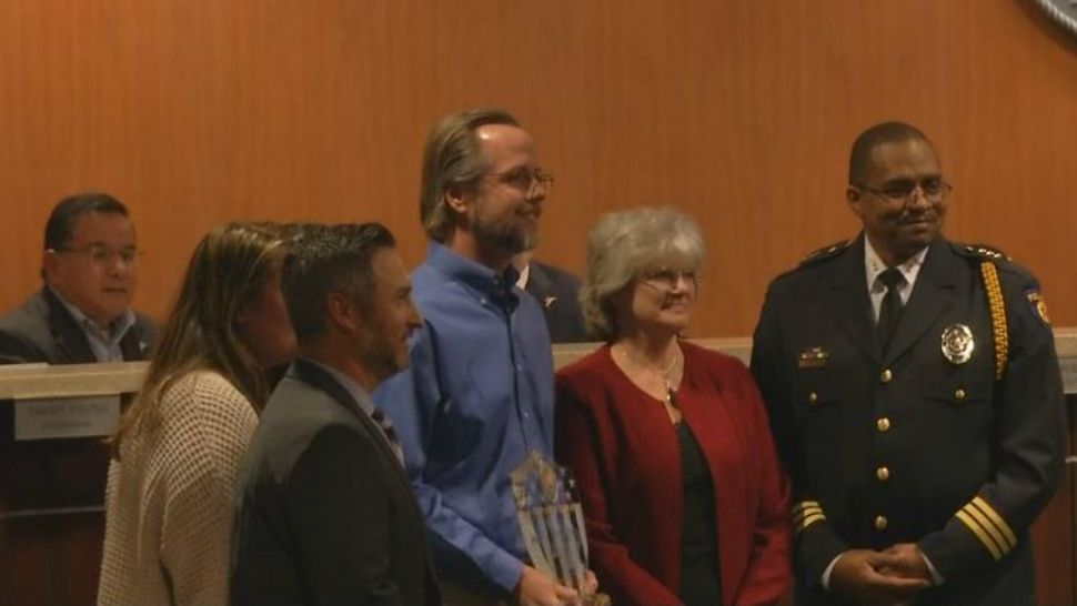 Dr. Robert Cinclair stands with his heroism award (Spectrum News footage)