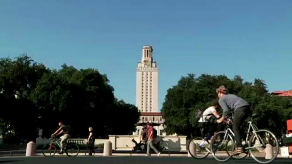 Students ride bicycles in front of UT tower