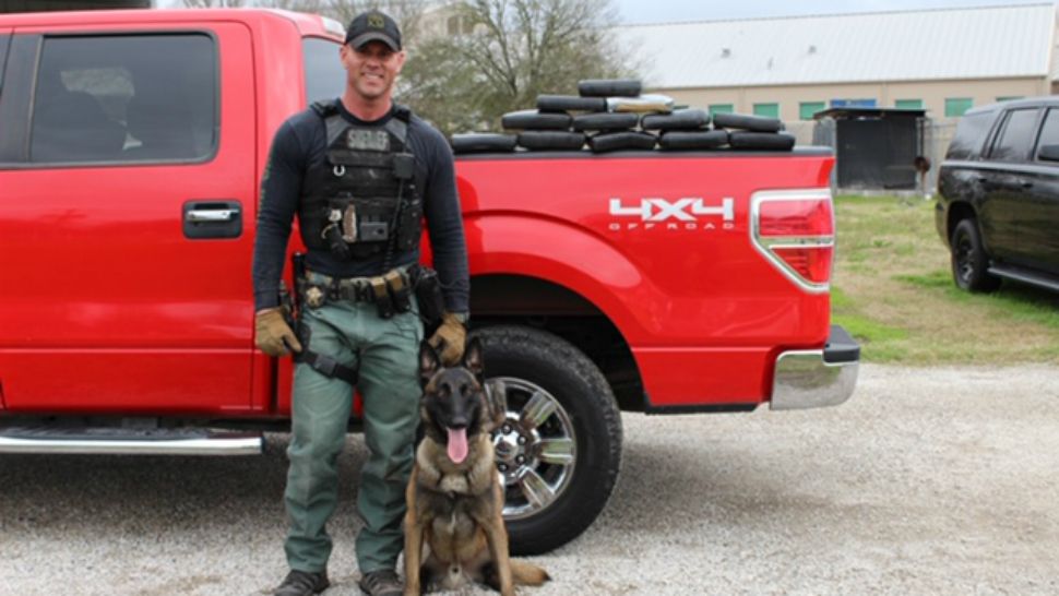Sergeant Randy Thumann and K-9 partner Kolt stand in front of a red truck full of cocaine (Photo credit: Fayette County Sheriff's Office)