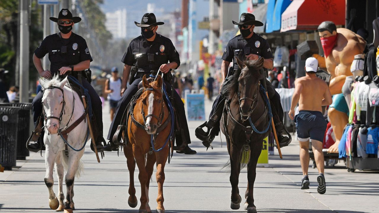 Los Angeles police officers patrol the Venice Beach boardwalk on horseback during the coronavirus outbreak, Wednesday, May 13, 2020. (AP Photo/Mark J. Terrill)