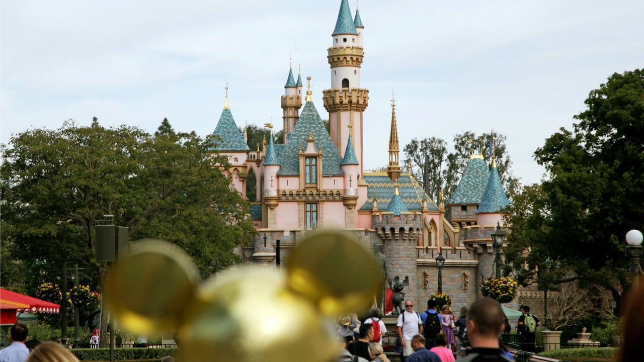 In this file photo, visitors walk toward Sleeping Beauty's Castle in the background at Disneyland Resort in Anaheim, Calif. (AP Photo/Jae C. Hong, File)