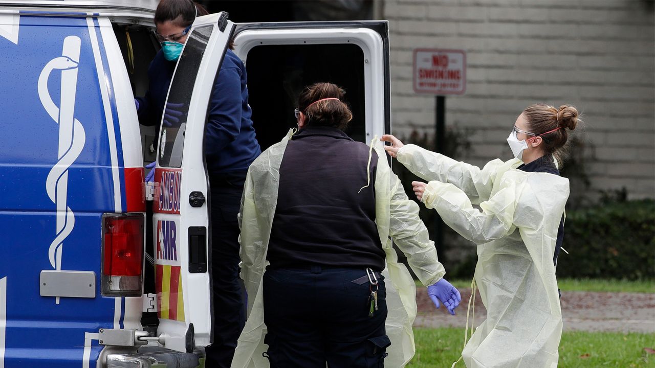 In this file photo from April 8, 2020, ambulance personnel get ready to evacuate patients from the Magnolia Rehabilitation and Nursing Center in Riverside. (AP Photo/Chris Carlson)