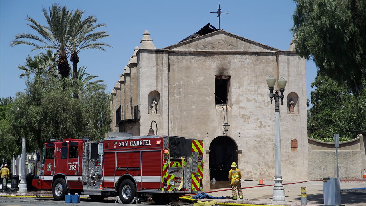 A firefighter stands outside the San Gabriel Mission in the aftermath of a fire, Saturday, July 11, 2020, in San Gabriel, Calif. The fire destroyed the rooftop and most of the interior of the nearly 250-year-old California church that was undergoing renovation. (AP Photo/Marcio Jose Sanchez)