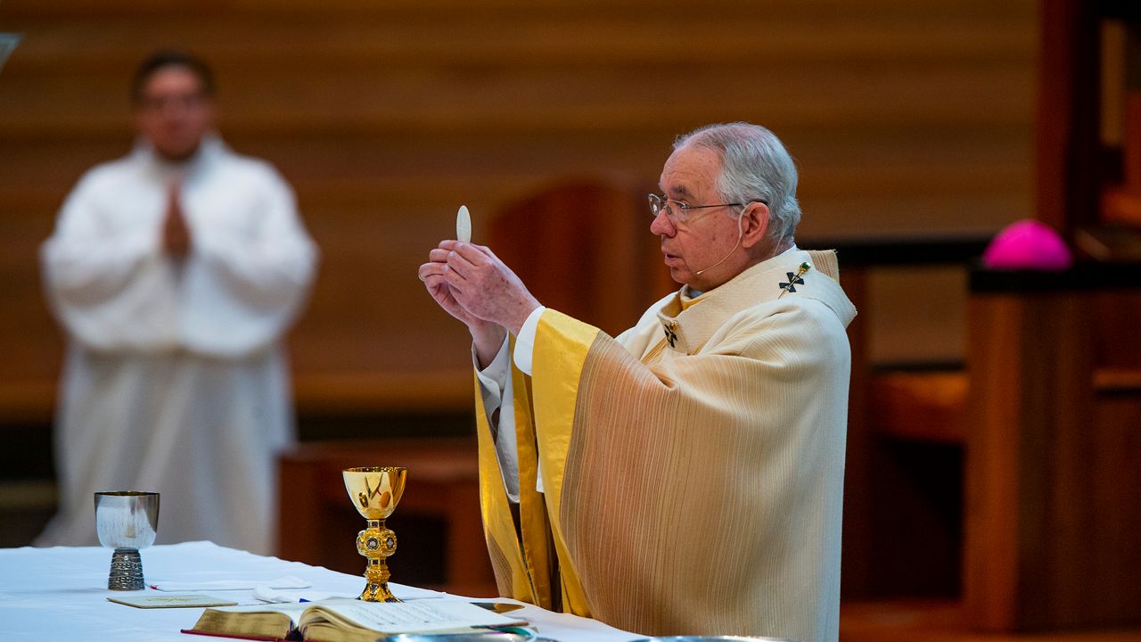 In this file photo from June 7, 2020, Archbishop Jose H. Gomez celebrates the Solemnity of the Most Holy Trinity, a Mass with churchgoers present at the Cathedral of Our Lady of the Angels in downtown Los Angeles. After new guidelines limit holding services inside, Masses will be offered online. (AP Photo/Damian Dovarganes)